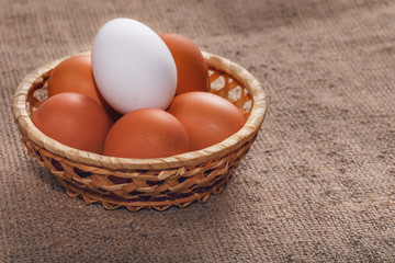 Easter composition. Several eggs in a straw basket on a cloth napkin