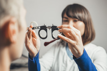 optometrist picks up glasses to correct astigmatism guy. concept of visual impairment in adults.