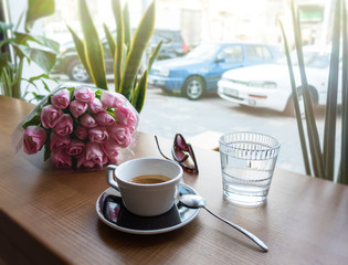 Coffee and spring flowers on coffee shop. Good mood concept.