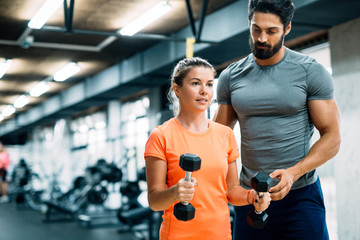 Young beautiful woman doing exercises with personal trainer