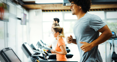 Young handsome man doing cardio training in gym