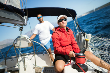 Attractive strong woman sailing with her boat