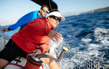 Attractive strong woman sailing with her boat