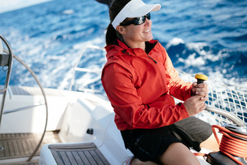 Attractive strong woman sailing with her boat