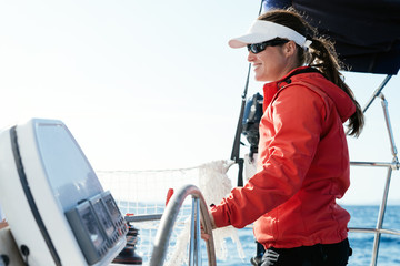 Attractive strong woman sailing with her boat