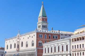 Fototapeta na wymiar St Mark's Campanile (Campanile di San Marco) and Doge's Palace ( Palazzo Ducale) on a background of blue sky, Venice, Italy