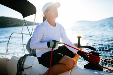 Attractive strong woman sailing with her boat