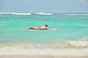 Surfer man with surfboard enjoying on the beach. Summer concept.