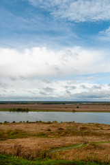 Rural landscape near the Konstantinovo village with clouded skies and meadows and hills