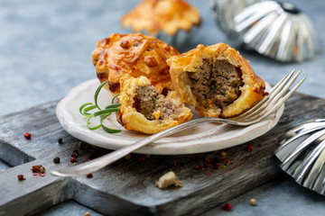 Mini pies stuffed with meat, onion and apple sauteed with butter.