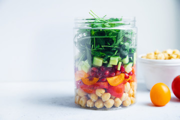 Healthy salad with chickpeas and arugula in a jar. Take away easy lunch concept