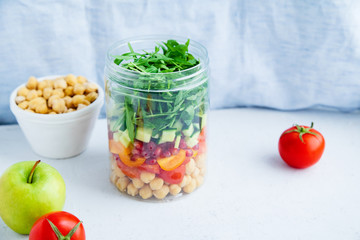 Healthy salad with chickpeas and arugula in a jar. Take away easy lunch concept