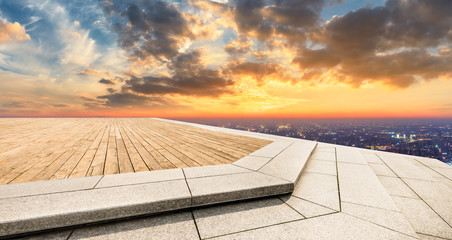 Fototapeta na wymiar Empty wooden platform and modern city skyline with beautiful colorful clouds at sunset