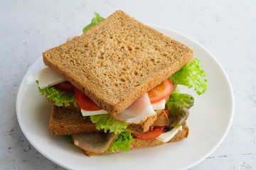 Healthy sandwich with greens, ham, tomatoes and cheese. Side angle. Lunch ideas for school or for work