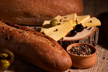 Slices of cheese on wooden desk between different breads. place for text