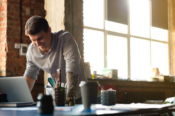 A man in a modern office works at the computer