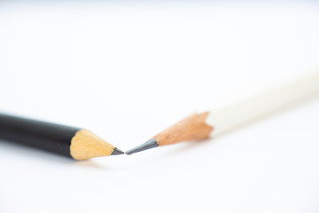A white pencil with a black pencil on white background, Close up & Macro shot, Selective focus, Stationery concept