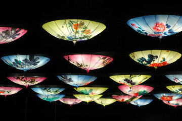 Traditional oriental umbrellas hanging as lanterns. Abstract city nightlife background concept