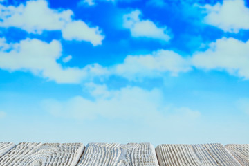 White wooden table with empty space on blue sky background