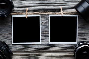 Two vintage photo frames with empty space and old lenses on wooden table
