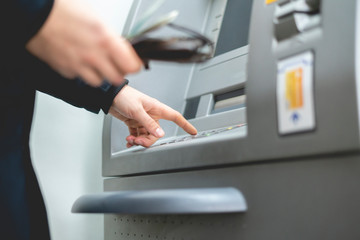 persons hand insert card in cash dispenser b