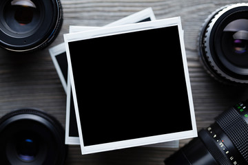 Old black lenses and classic photo frames on wooden background