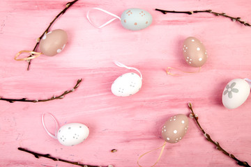 Easter eggs on pink background with willow branch.