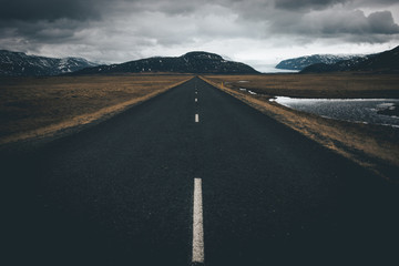 photogenic endless road in iceland leading towards oncoming storm on the horizon 