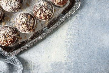 Tray with tasty almond muffins on table