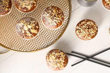 Tasty almond muffins on white table