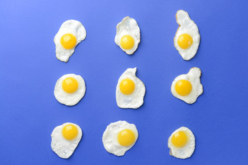 Tasty fried eggs on color background