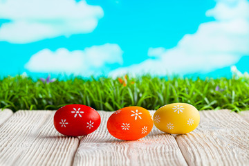 Three Easter eggs on white table and nature background