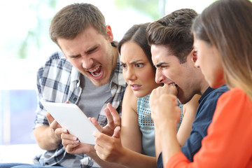Angry group of friends watching media on tablet