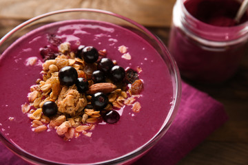 Bowl with tasty acai smoothie on table, closeup