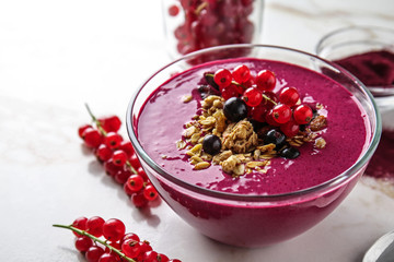 Bowl with tasty acai smoothie on light table