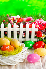 Colorful Easter eggs in the nest on wooden table and nature background