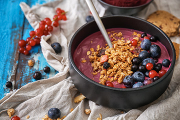 Bowl with tasty acai smoothie on table
