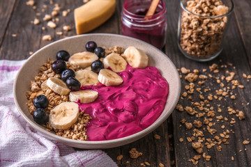 Bowl with tasty acai smoothie on wooden table