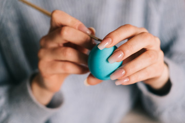 Hands of person painting the egg decoration for easter.