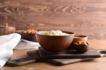 Bowls with tasty almond flour and nuts on wooden table