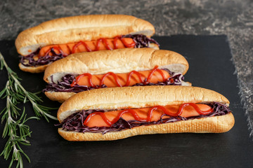 Tasty hot dogs on slate plate
