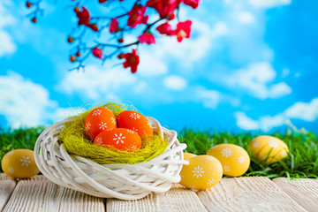 Easter eggs in the nest and wooden table on nature background