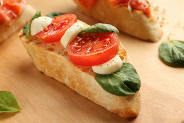Fresh tasty bruschetta on wooden board, closeup