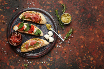 Plate with fresh tasty bruschettas on color background