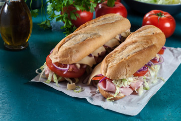 Submarine sandwiches with ham, cheese and vegetables