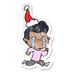 distressed sticker cartoon of a man crying wearing santa hat