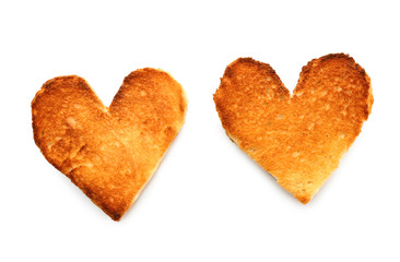 Heart-shaped slices of toasted bread on white background