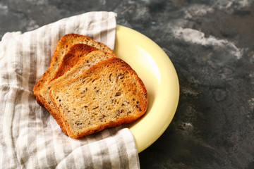 Plate with toasted bread on grunge background