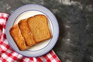 Plate with tasty toasted bread on grunge background