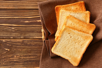 Tasty toasted bread on wooden table